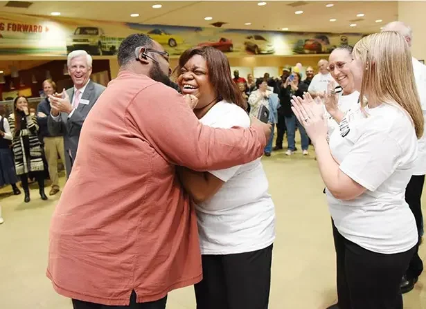 two people hugging amongst a crowd of people img